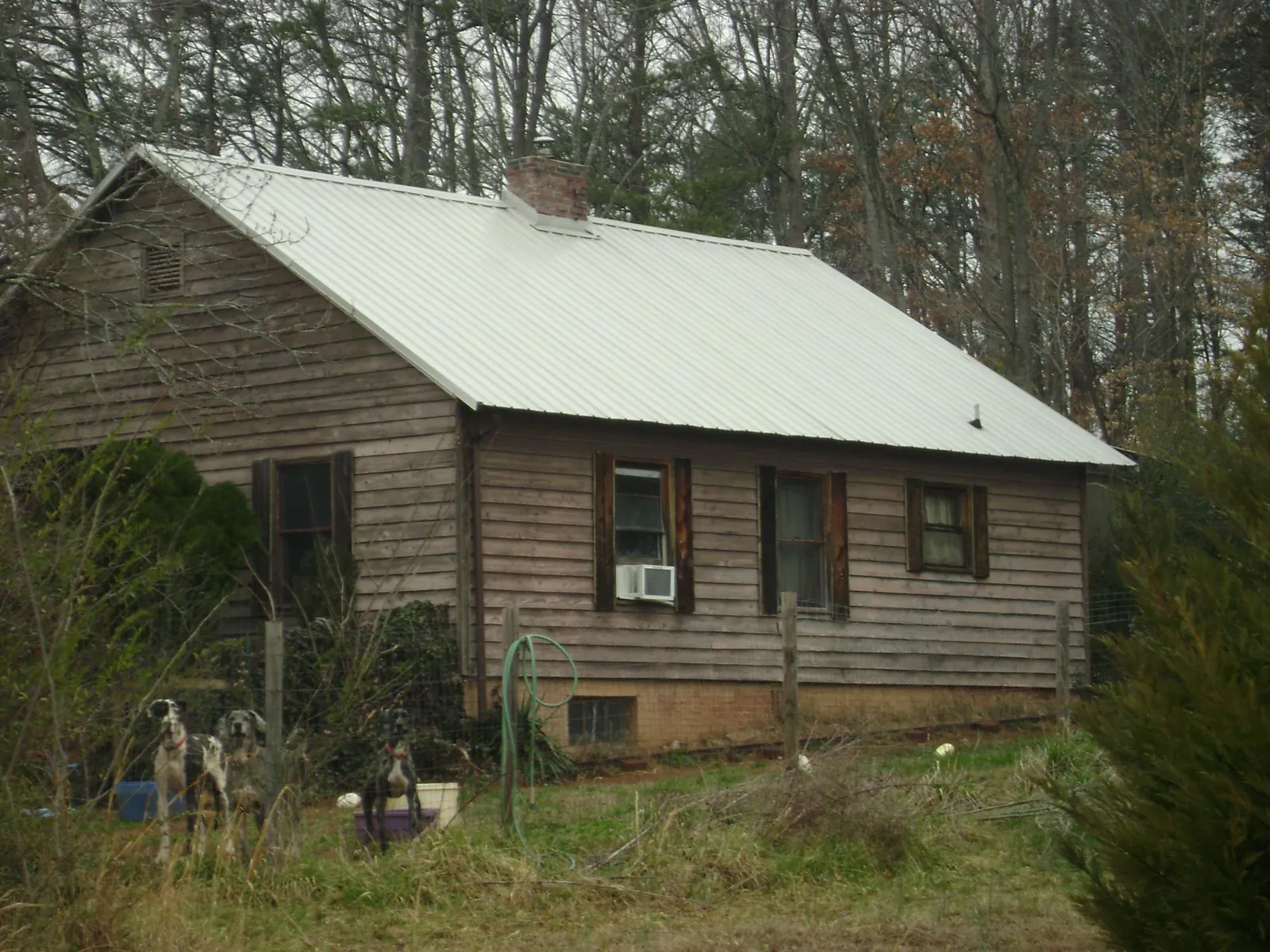 White metal roof on an old wood sided farmhouse, from a Asphalt Shingle Roof Repair job in Marietta